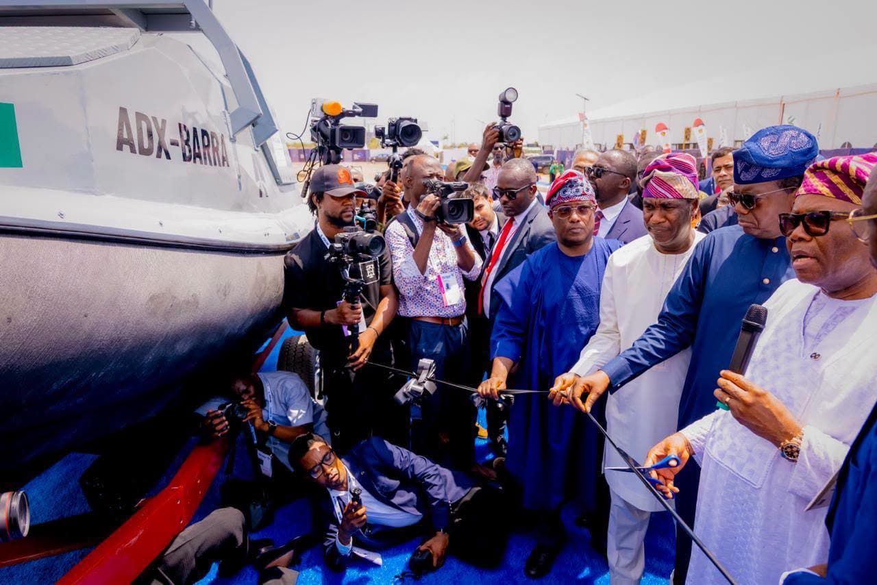 Dignitaries and press photographers beside the ADX-Barra vessel at AFRIDEX 2026.