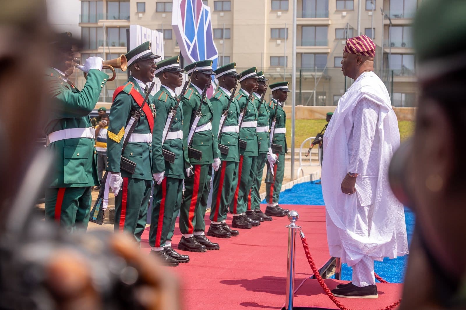 Senate President Godswill Akpabio, in white, inspecting a guard of honour on a red carpet at Eko Atlantic.