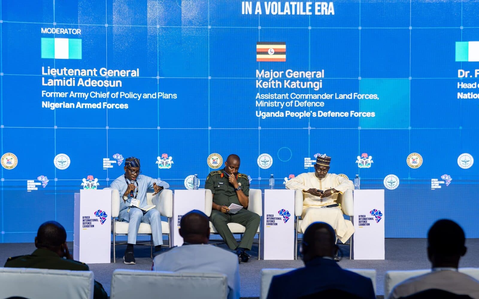 The Securing Borders and Internal Stability panel on stage, with the moderator's and speakers' names on the screen.