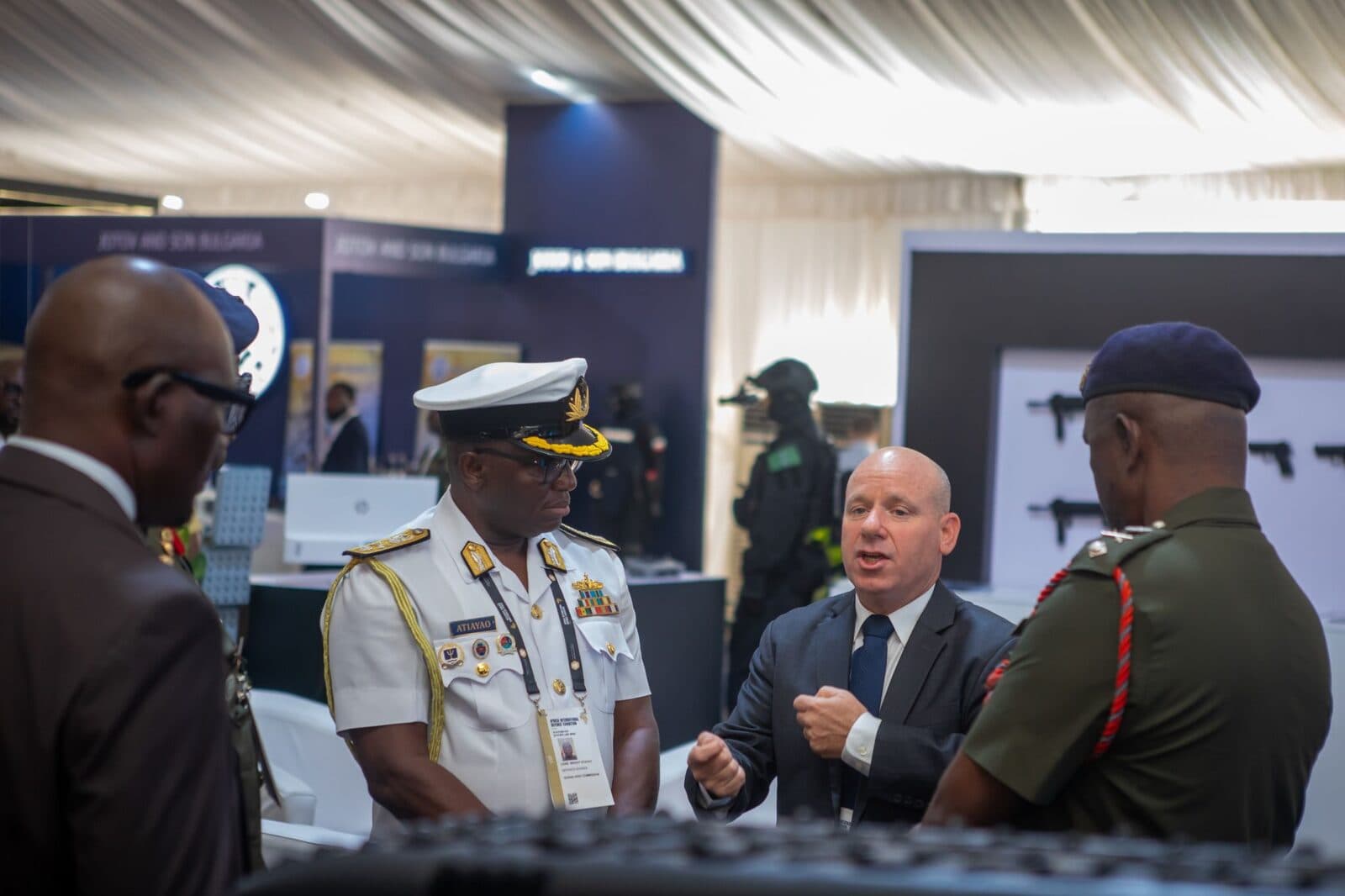 A Nigerian Navy officer and an Army officer in conversation with an exhibitor at a stand on the final morning.